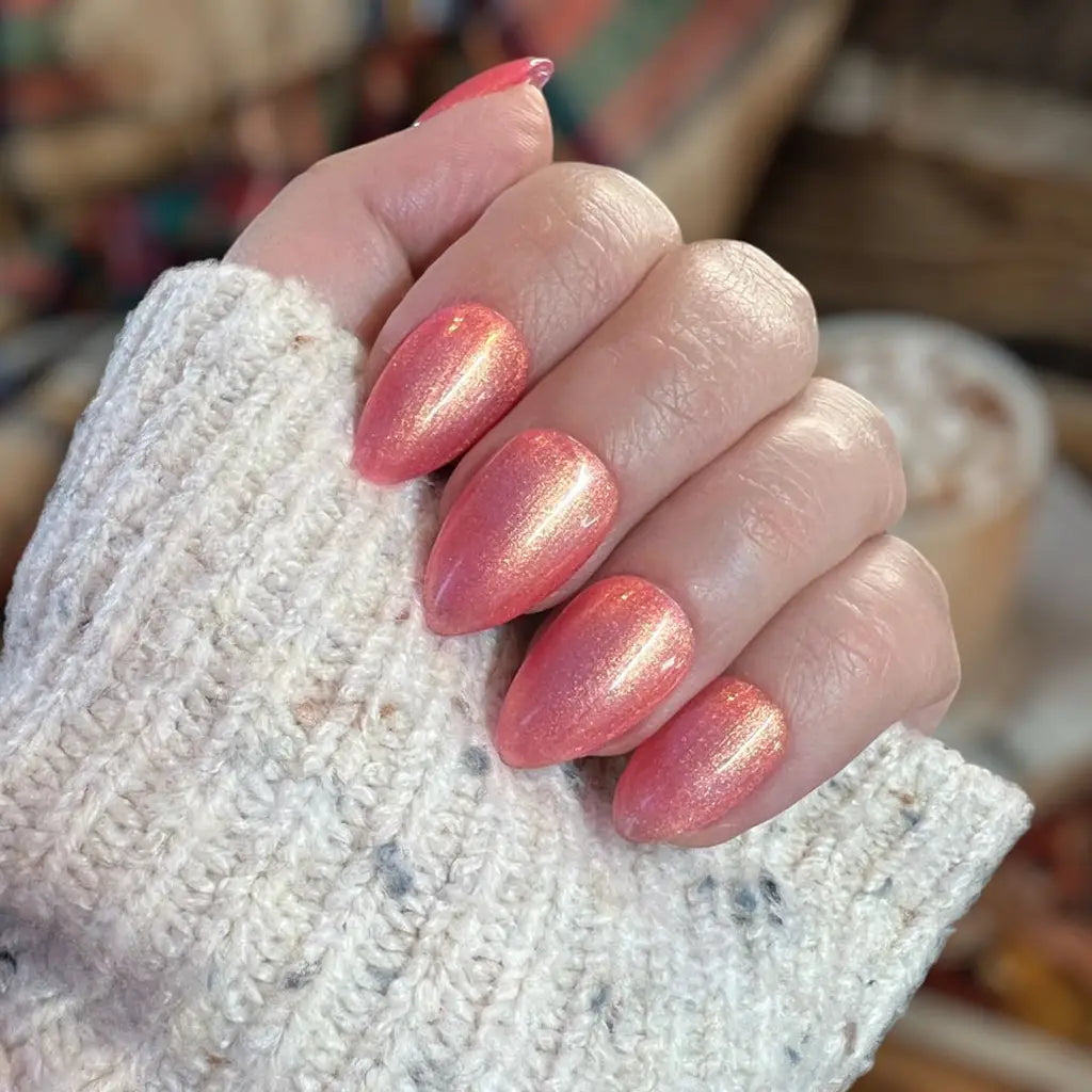 Close-up of fingers showcasing shimmering rose gold &